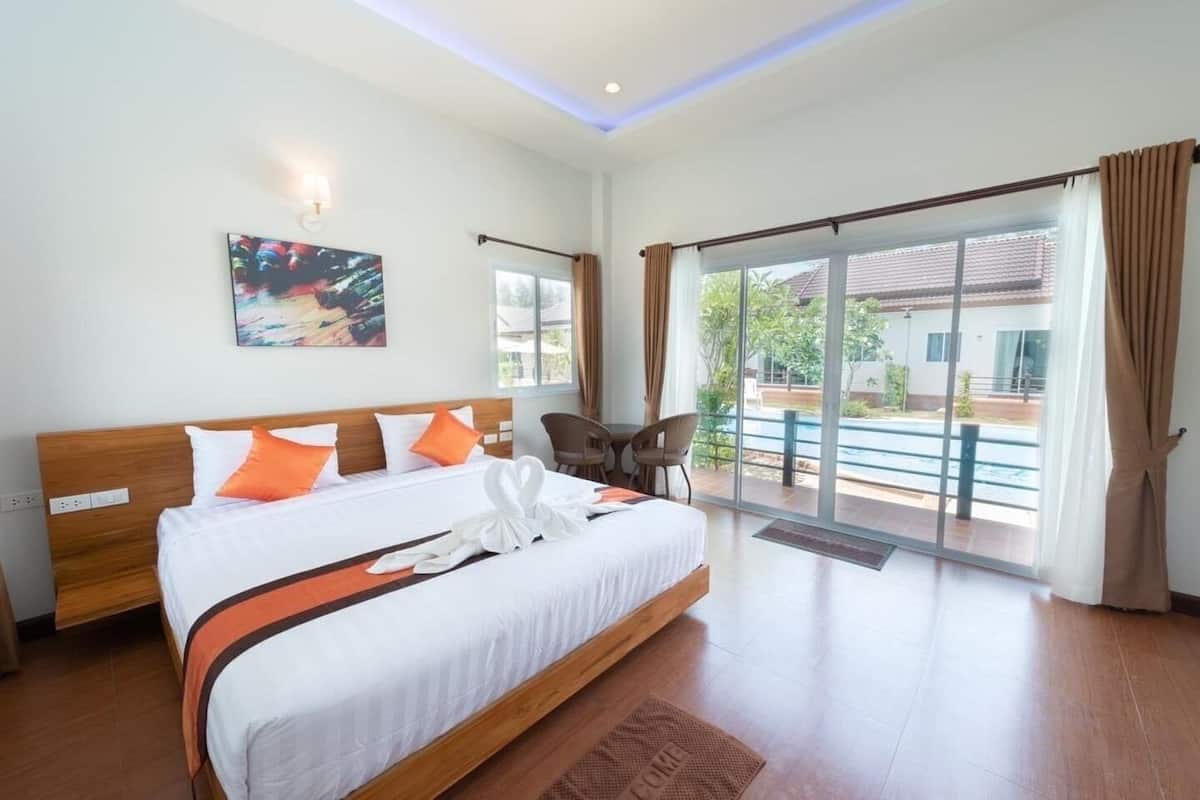 Una habitación de hotel con una cama grande, un escritorio y vistas al exterior.