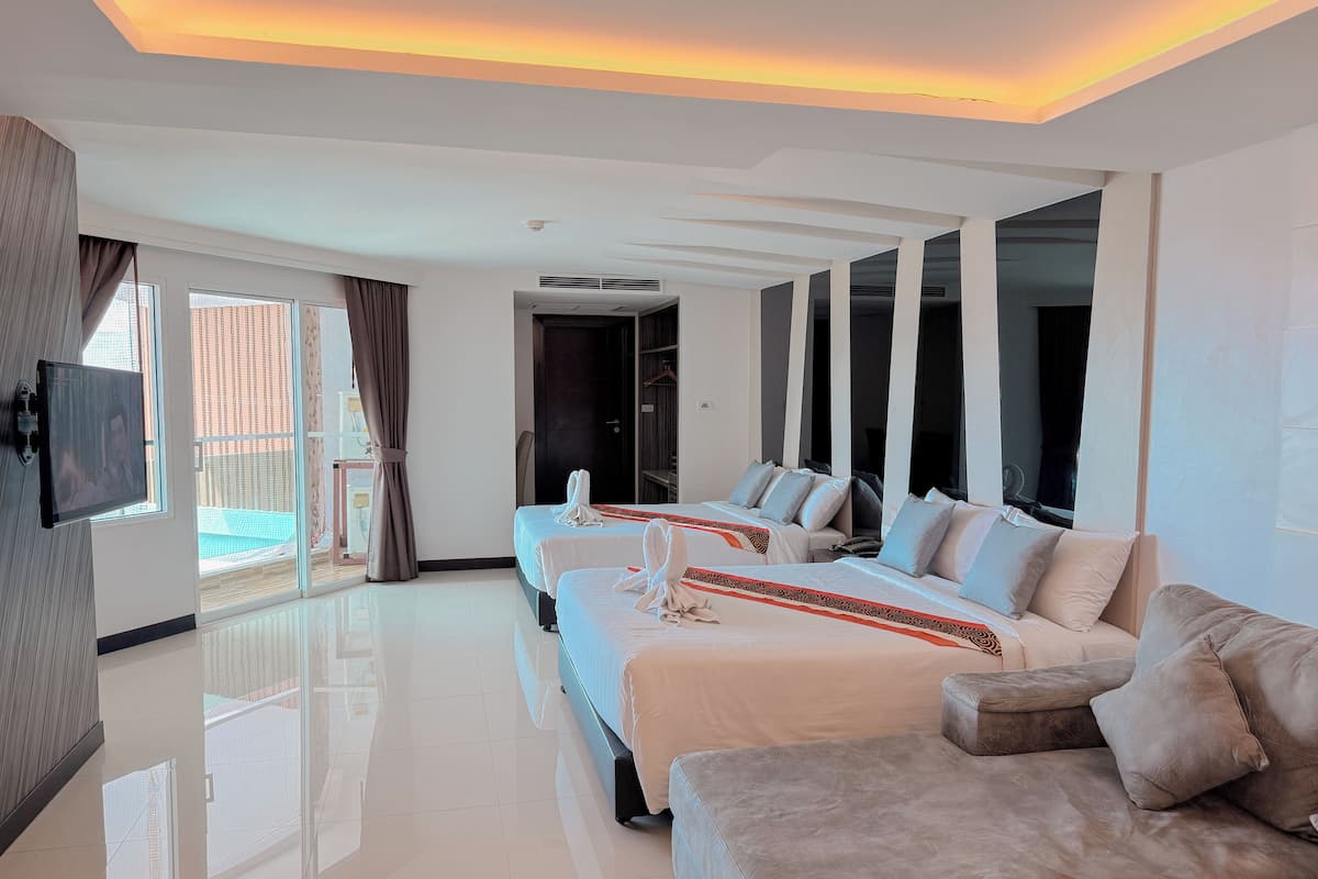 Ein modernes Hotelzimmer mit zwei Betten, einem Sofa, einem Fernseher und einem Balkon mit Blick.