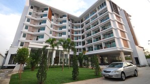 A multi-story building with a modern architectural design, featuring balconies and large windows. - Vareena Palace Hotel (Pattaya)