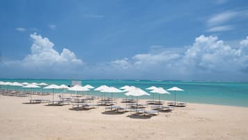 On the beach, white sand, sun loungers, beach umbrellas