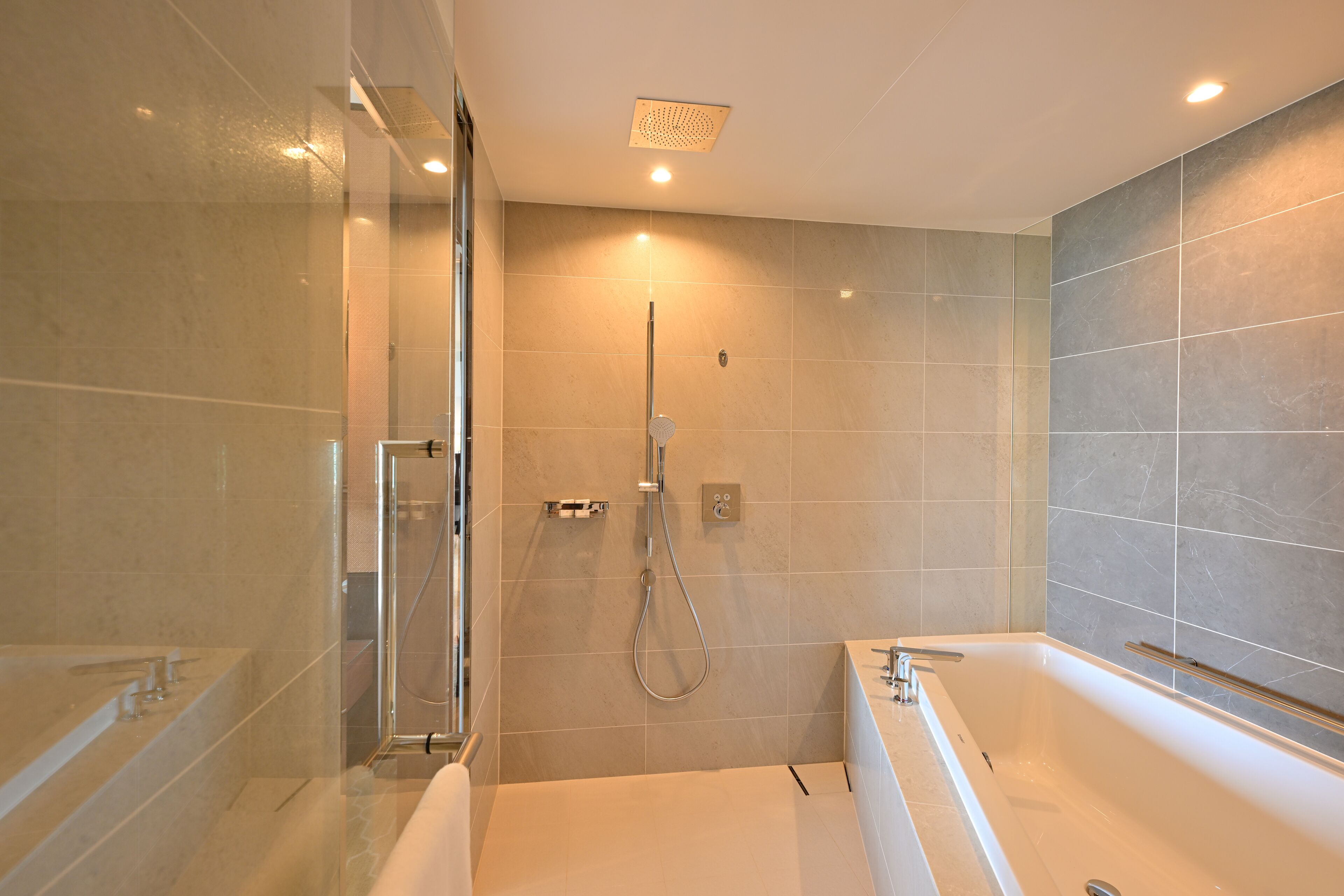 A modern bathroom with a glass-enclosed shower, a standalone bathtub, and a wall-mounted showerhead.