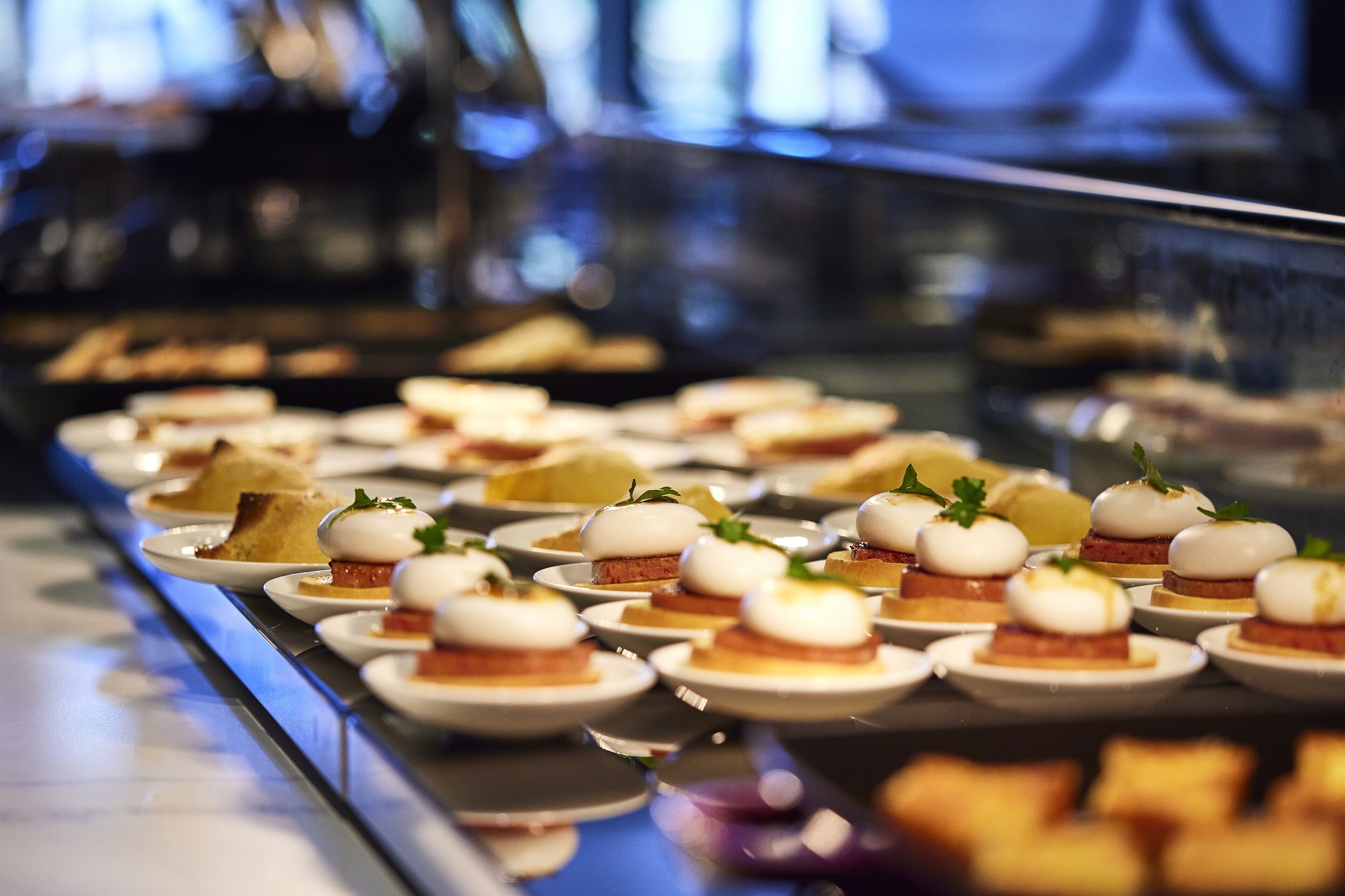 Un buffet proposant divers plats, dont certains sont agrémentés d’œufs pochés et de différentes garnitures.