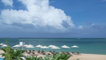 On the beach, white sand, sun loungers, beach umbrellas