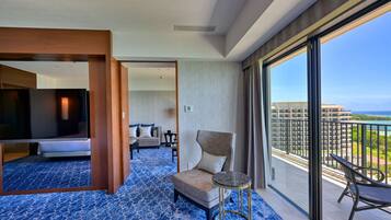A hotel room with a large balcony, a bed, a chair, and a small table.