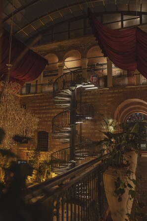 A grand interior with a spiral staircase, ornate railings, and a large chandelier. - Han 1772 Hotel (Istanbul)