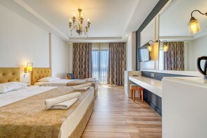 A hotel room with three beds, a desk, and a large mirror. - SEY BEACH HOTEL &SPA (Alanya)