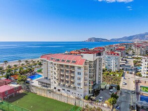 Un hôtel situé sur la côte, avec plusieurs étages, une piscine et une vue sur la mer.