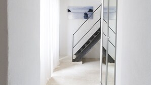 Un interior moderno con una escalera que lleva a un balcón.