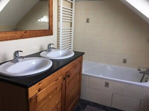 Een bad/douchecombinatie, handdoeken