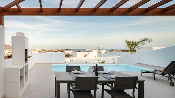A rooftop terrace with a pool, dining table, and chairs. - Villa Amade, con Piscina Privada (Playa Blanca (Yaiza))