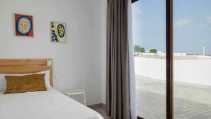 Una camera da letto con un letto, un tavolino e due opere d'arte appese al muro.