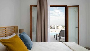 Een hotelkamer met een bed, uitzicht op een zwembad en een open deur naar buiten.