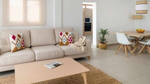 Un salon moderne avec un canapé, une table basse et un coin repas.