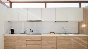A modern kitchen with white cabinets, a wooden countertop, a coffee maker, a toaster, and a sink. - Villa Alba, con Piscina Privada (Playa Blanca (Yaiza))
