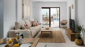 Uma sala de estar moderna com sofá, mesa de centro e espaço para café da manhã.