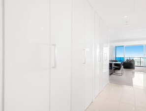 Een moderne, lichte hotelkamer met een groot raam en uitzicht op zee.