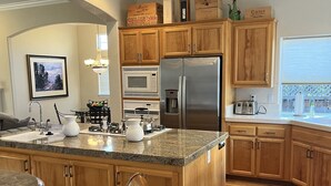 A modern kitchen with wooden cabinets, stainless steel appliances, and a granite countertop. - Beautiful Home Walking Distance St Helena and Meadowood resort privileges. (St Helena)