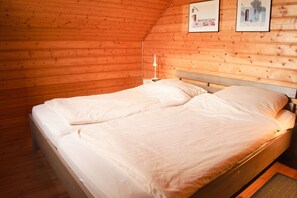 A single bed in a room with wooden walls and a sloped ceiling. - The House to Stay for Perfect Holidays (Oberharz am Brocken)