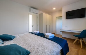 Una habitación de hotel moderna con una cama grande, un escritorio y una silla.