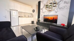 Ein modernes Wohnzimmer mit Flachbildfernseher, Marmorwand und sechseckigem Regal.