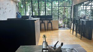 Um hall de hotel moderno com balcão de recepção, área de bar e assentos.