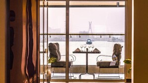 A balcony with a view of a bridge and a table with chairs. - The Yacht Hotel (Lekki)