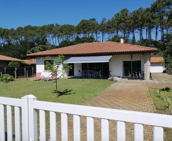 Enjoy a patio area and a lush lawn at this single-story house with a covered outdoor space.