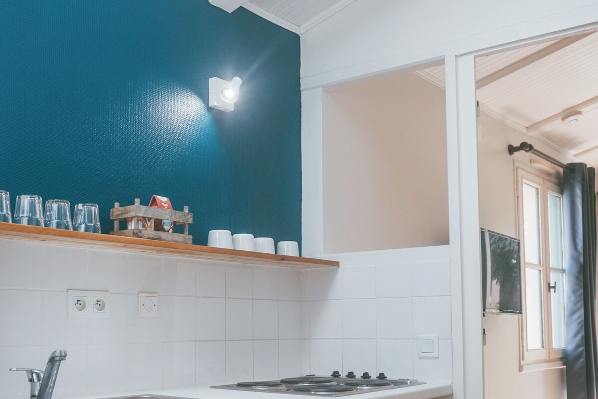 A kitchen with a white sink, a stove, and a window above the counter.