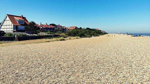 Une plage avec des maisons en arrière-plan.
