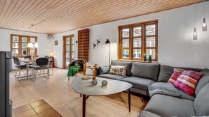 A spacious living area with a wooden ceiling, a grey sofa, a round coffee table, and a dining area with a table and chairs. - Pet friendly home in Videbæk with WiFi (Videbæk)