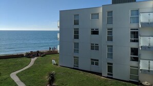 Un edificio moderno con diversi piani, un tetto piatto e vista sul mare.