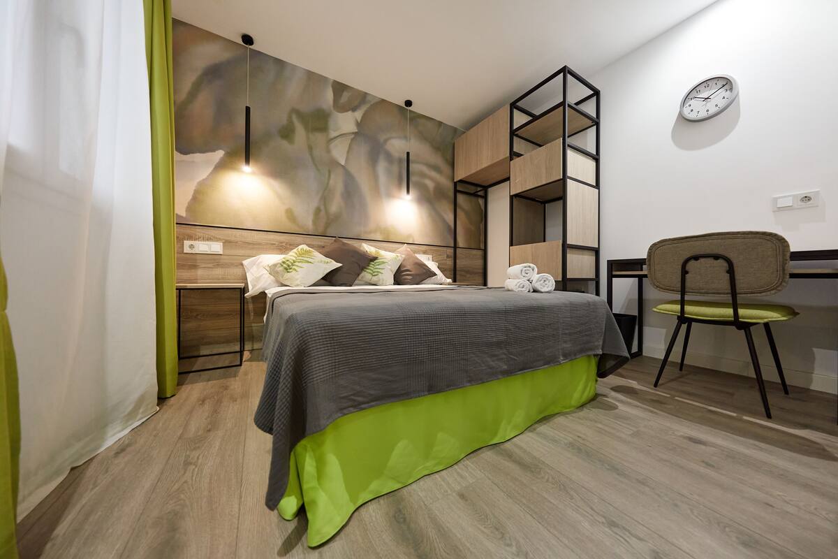 A modern bedroom with a bed, a desk, and a chair.