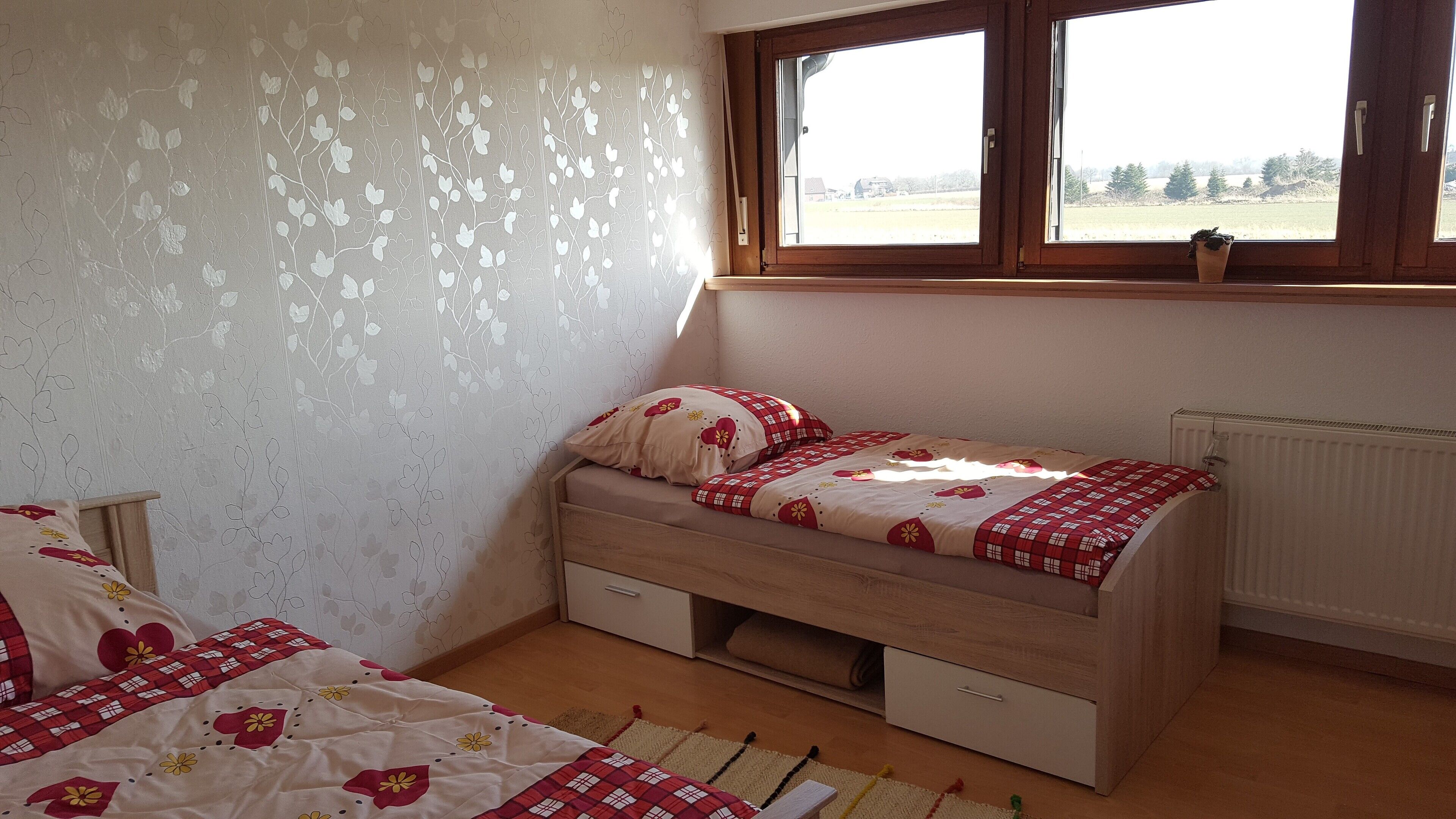 Un dormitorio con una cama individual, una ventana y un radiador.