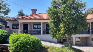 A two-story building with a red-tiled roof, stone walls, and a balcony. - Typical house with swimming pool (Sao juliao)