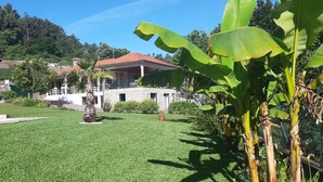 A well-maintained garden with a fountain, a stone building with a red roof, and lush greenery. - Typical house with swimming pool (Sao juliao)