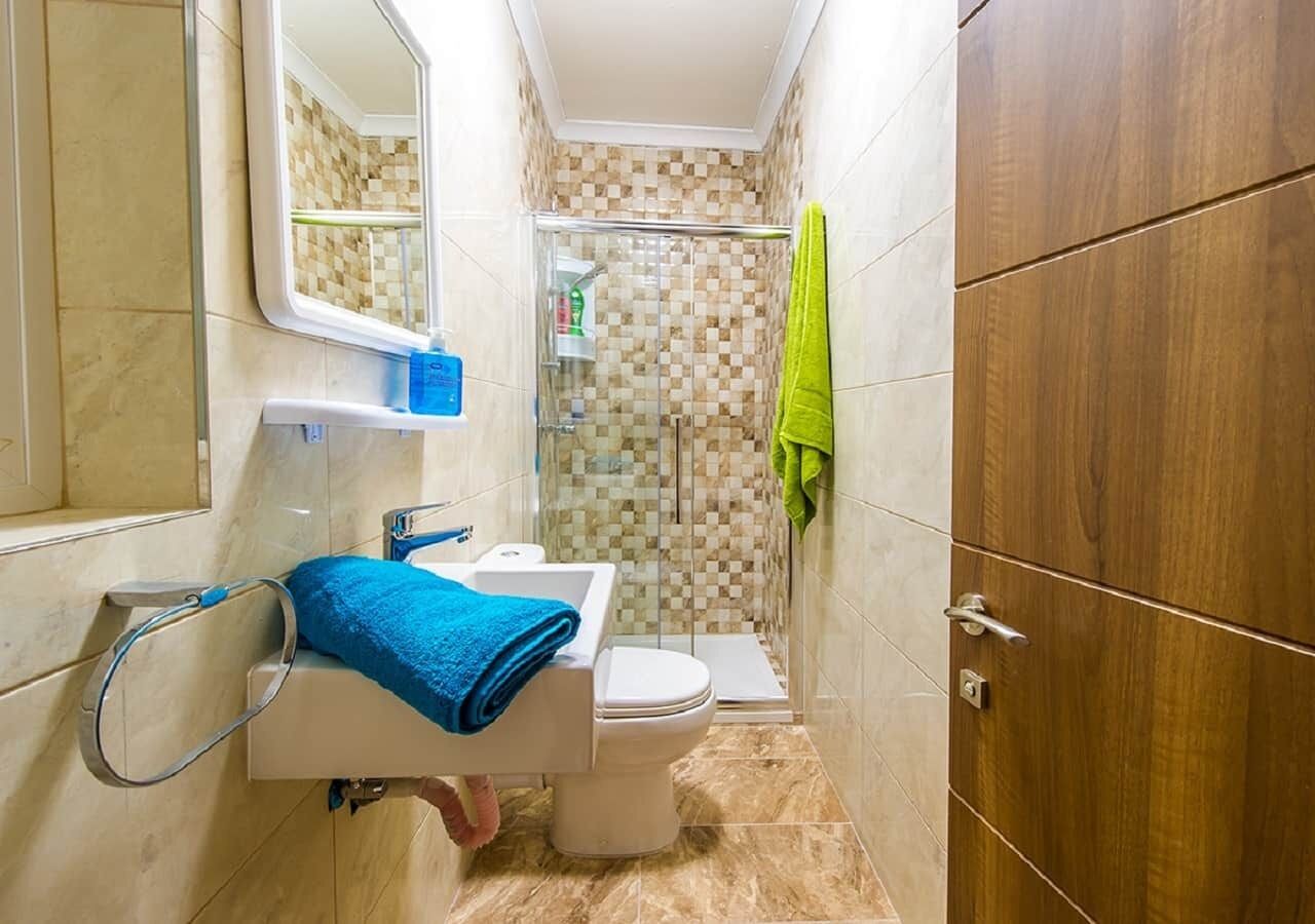Un baño pequeño con inodoro, lavamanos y zona de ducha.