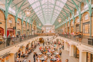 A spacious indoor market with high ceilings and arches, featuring various shops and dining areas. - Livestay - Hidden Covent Garden Gem (London)