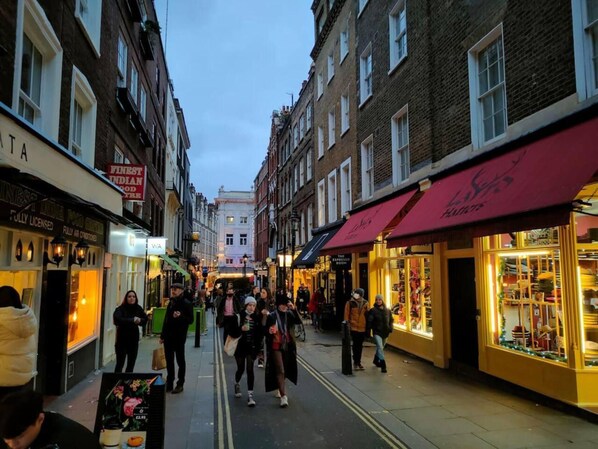 A busy street with shops and pedestrians. - Livestay - Hidden Covent Garden Gem (London)