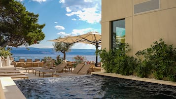 Una piscina al aire libre de temporada, sombrillas