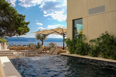 Una piscina al aire libre de temporada, sombrillas