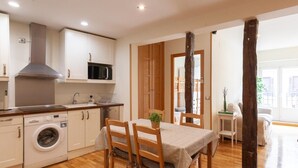 Uma cozinha compacta com máquina de lavar, micro-ondas e armários de madeira.