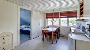A compact room with a bed, a dining table with chairs, a kitchenette, and a window with blinds. - 1 bedroom cozy apartment in Gullspång (Gullspång)