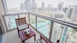 Un balcón con vistas a un paisaje urbano y una piscina.