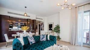 Una sala de estar moderna con un sofá color turquesa, un comedor y una cocina.