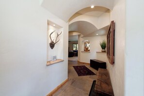A hallway with a wooden bench, a rug, and a mounted antler on the wall. - Largest Black Bear Townhome - Private Hot Tub - EV Charger - Ski Shuttle (Durango)