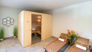 A spa room with wooden benches, a wooden sauna door, and a hexagonal wall decoration. - Aparthotel pod Stokiem (Szczyrk)