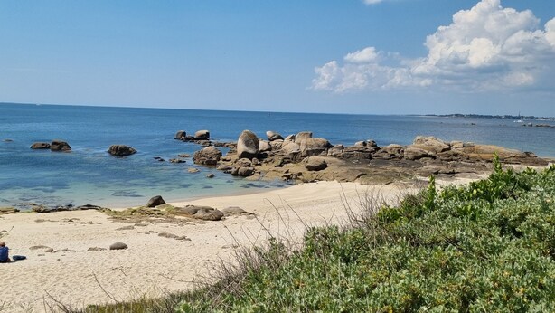A beach with clear blue water, large rocks, and a few people sitting on the sand. - Beautiful duplex with sea view balcony at Le Cabellou in Concarneau  (Concarneau)