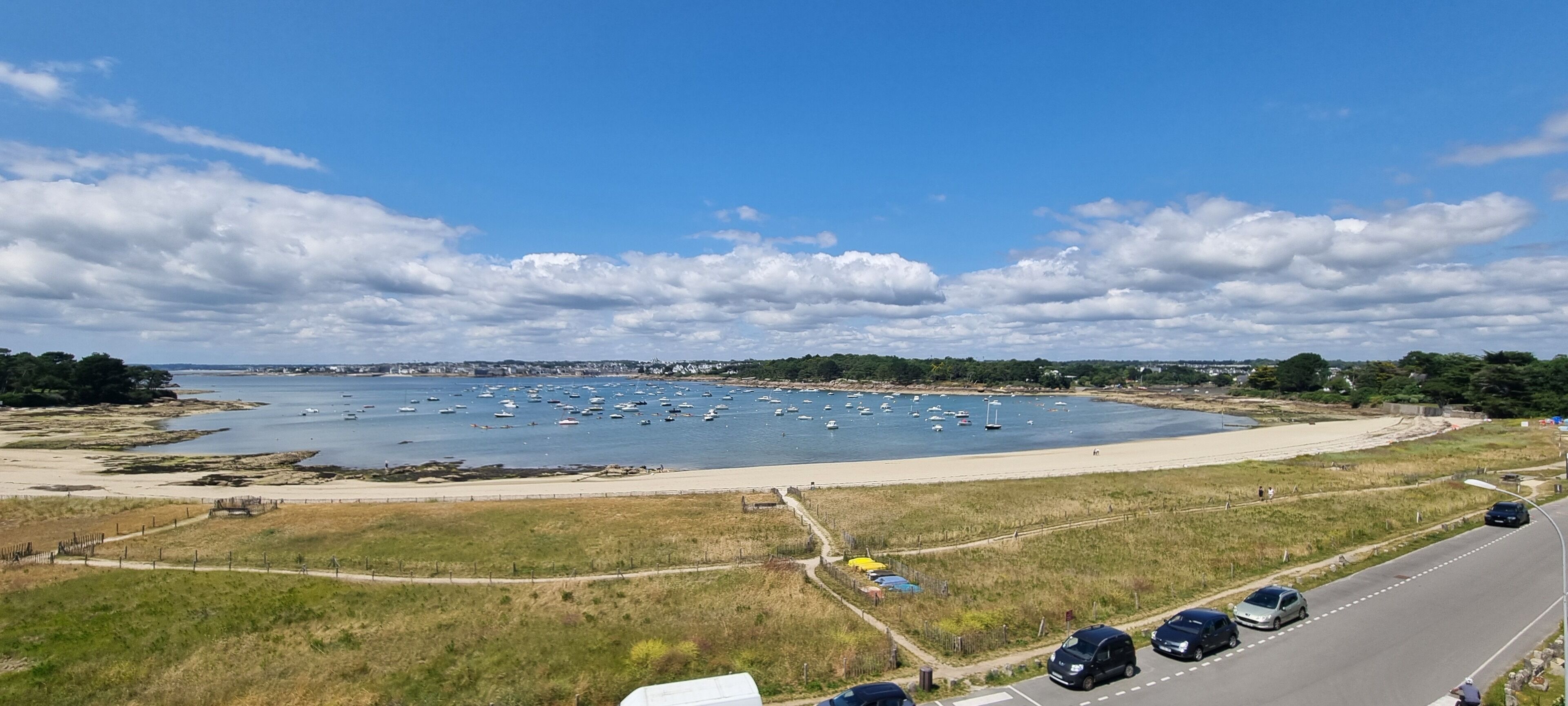 A coastal road with a beach and marina.