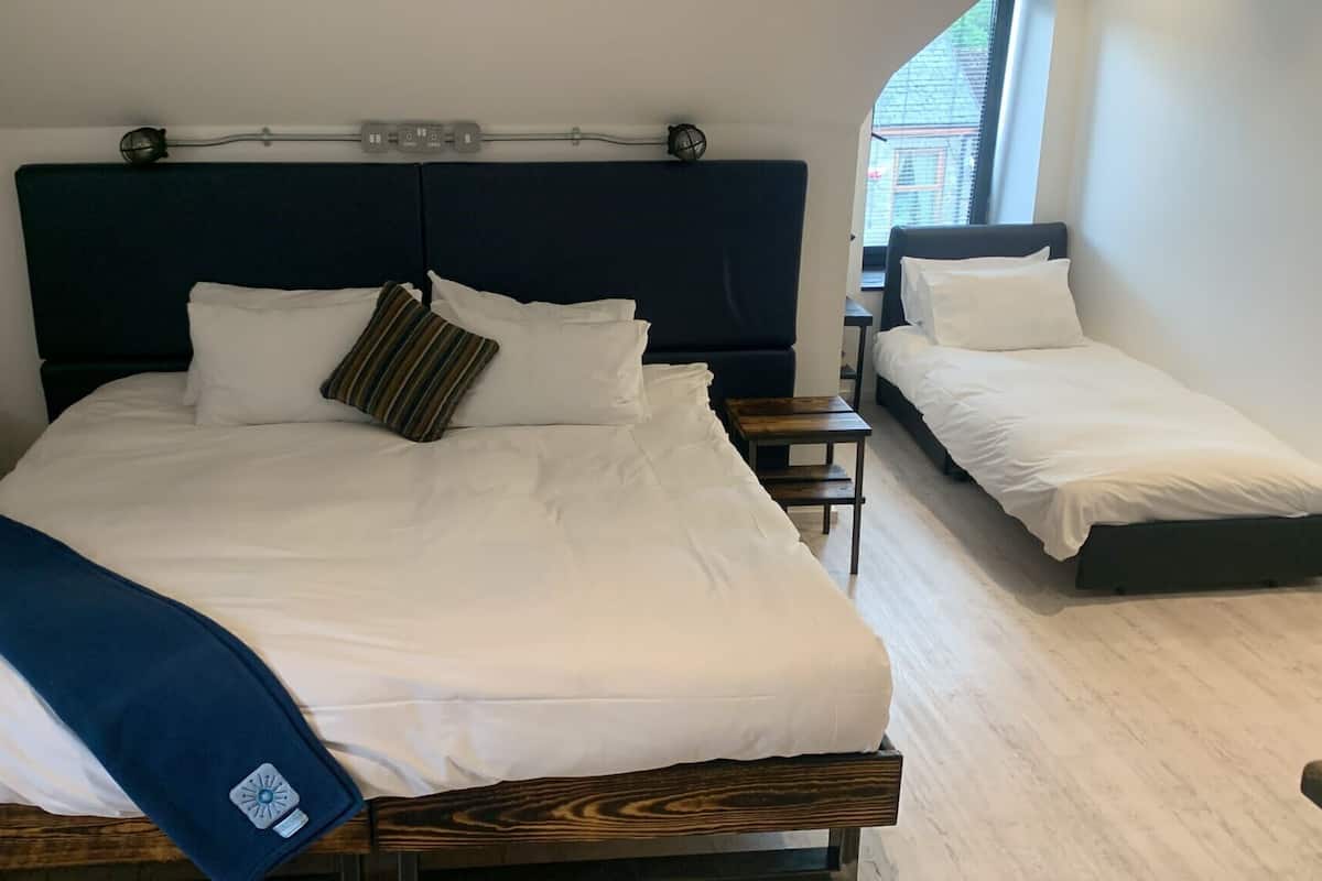 A double bed with a dark headboard, a bedside table, and a small bedside lamp.