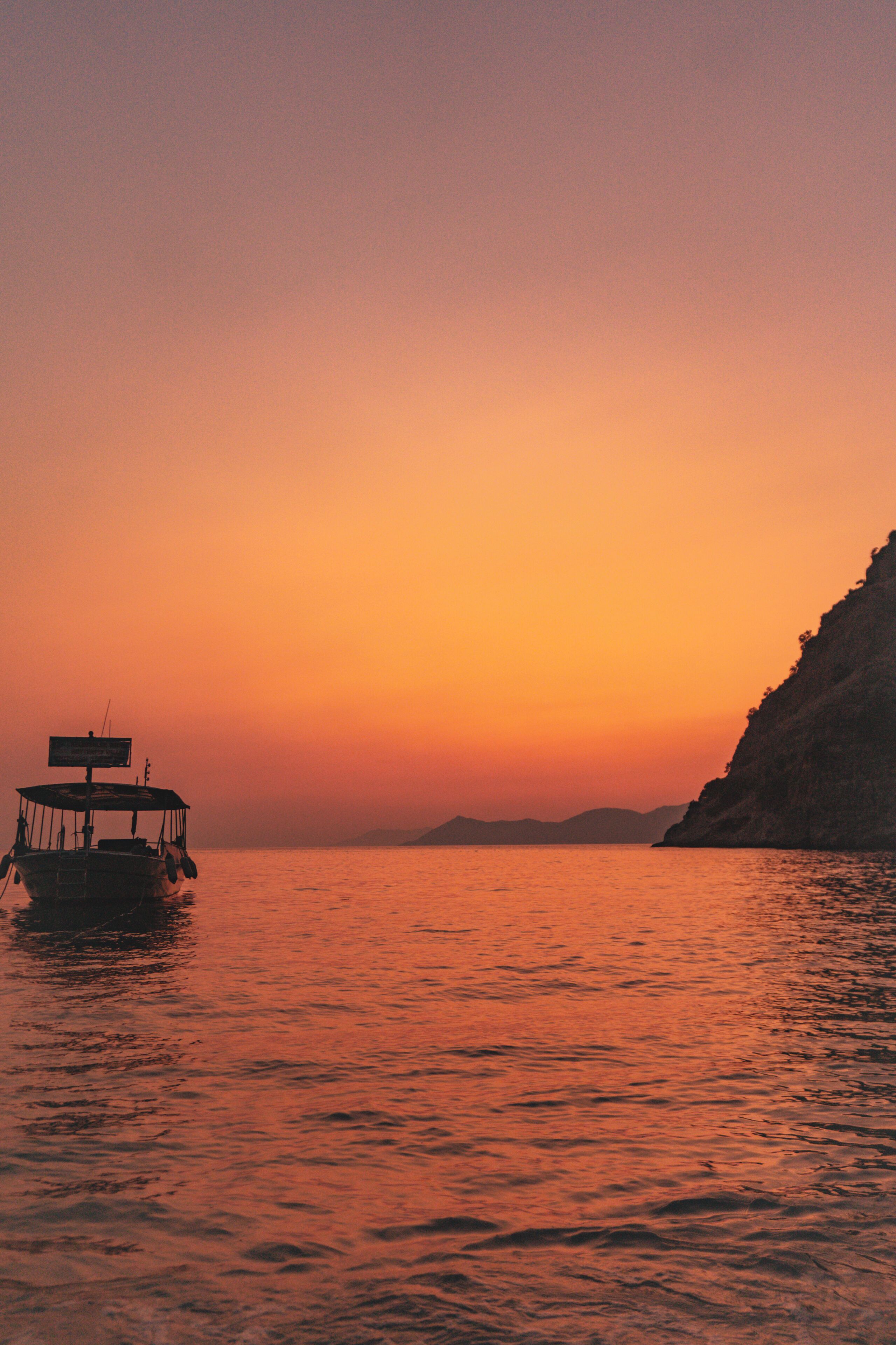 A boat on calm water during sunset.